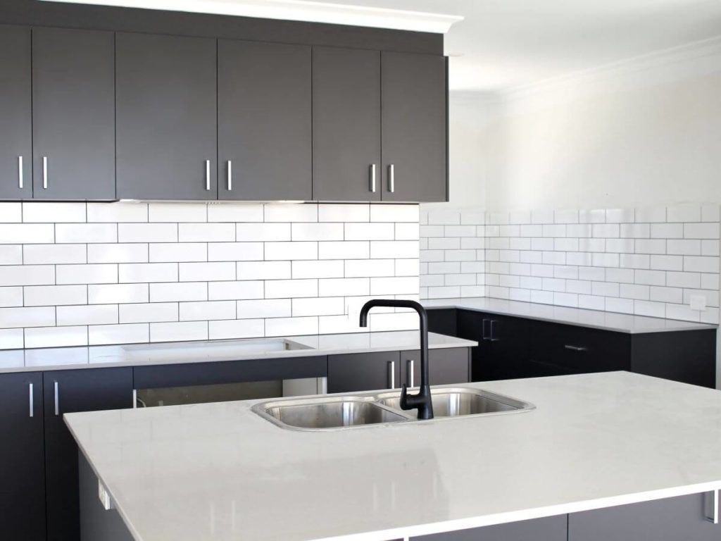 grey cabinets and white tiled kitchen