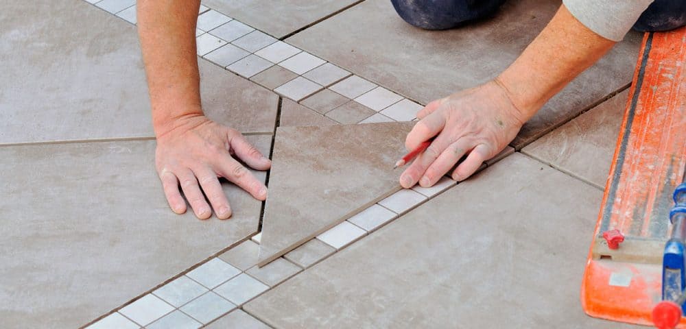 Tiler measuring up a tile for the floor