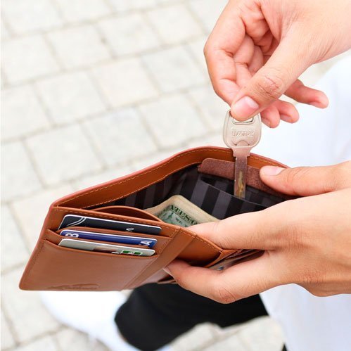 Person adding a key to their wallet